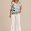307E718B-2D6D-4F68-B6CD-6EEAC2776EE4 Kalisson blue floral lace top with abstract botanical print, short sleeves and lightweight cotton blend fabric.