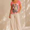 a_bright_softly_lit_studio_or_indoor_set_with_a_n Kalisson coral cotton T-shirt with artistic printed front panel