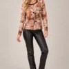 03: womens-abstract-face-print-top.webp Women's abstract face print long-sleeve top in beige, rust, brown and black tones